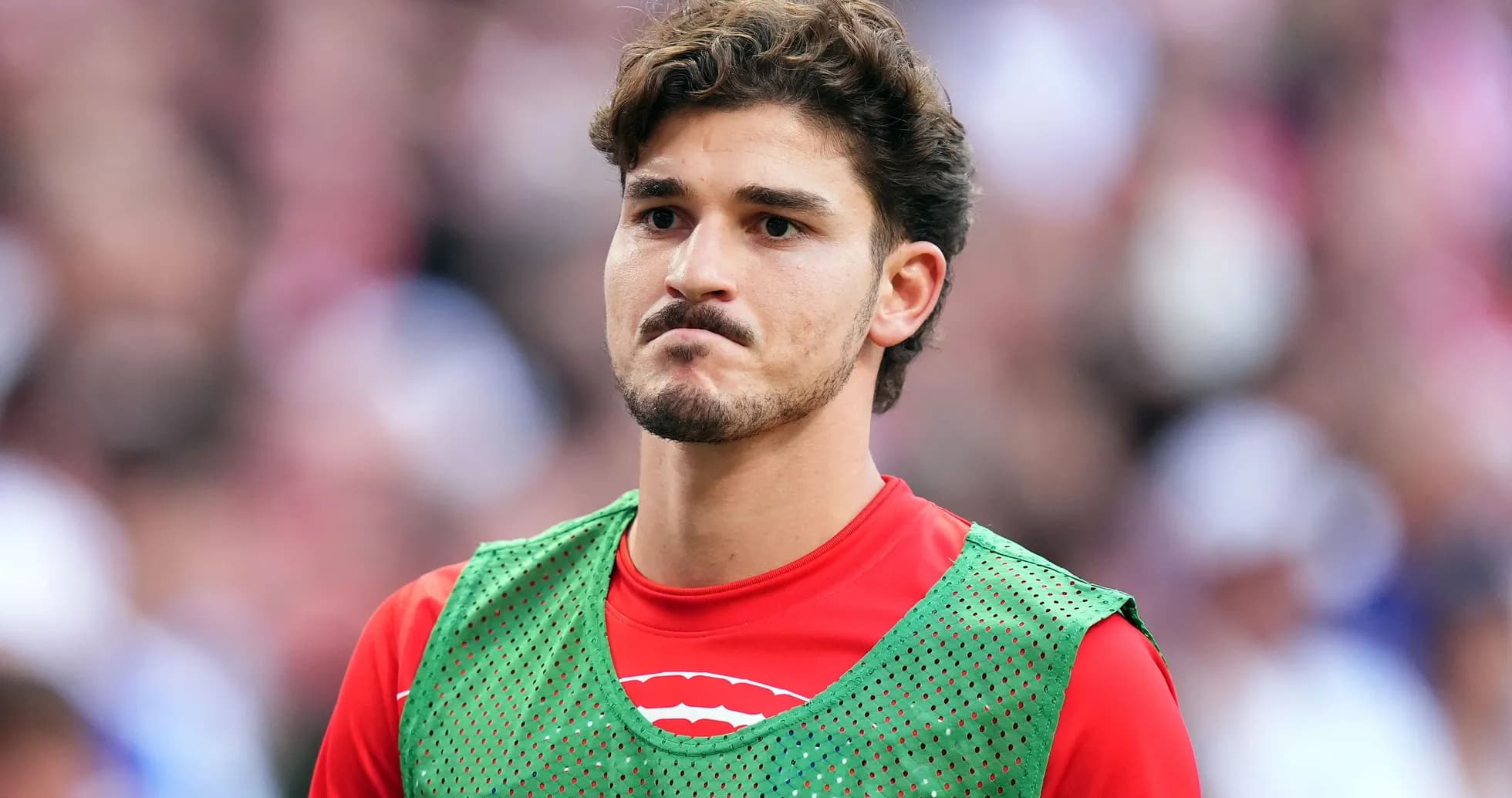 Player in training vest on sideline during match Player in training vest on sideline during match