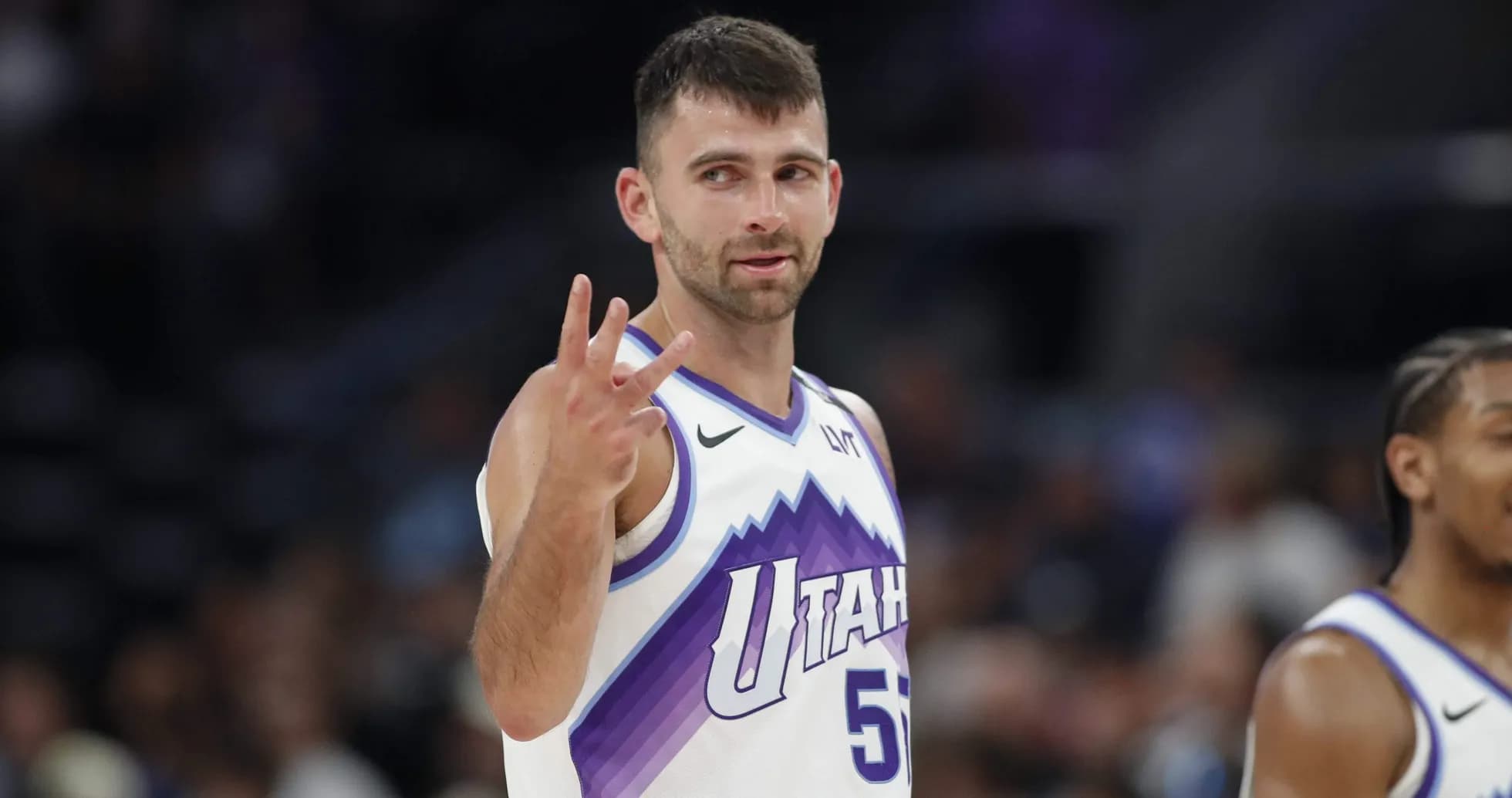 Player signaling three points during basketball game Player signaling three points during basketball game