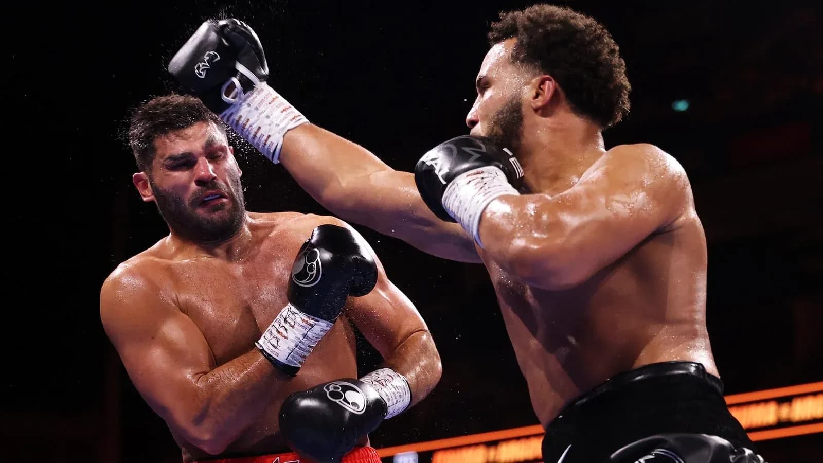 Two boxers exchanging punches in the ring Two boxers exchanging punches in the ring
