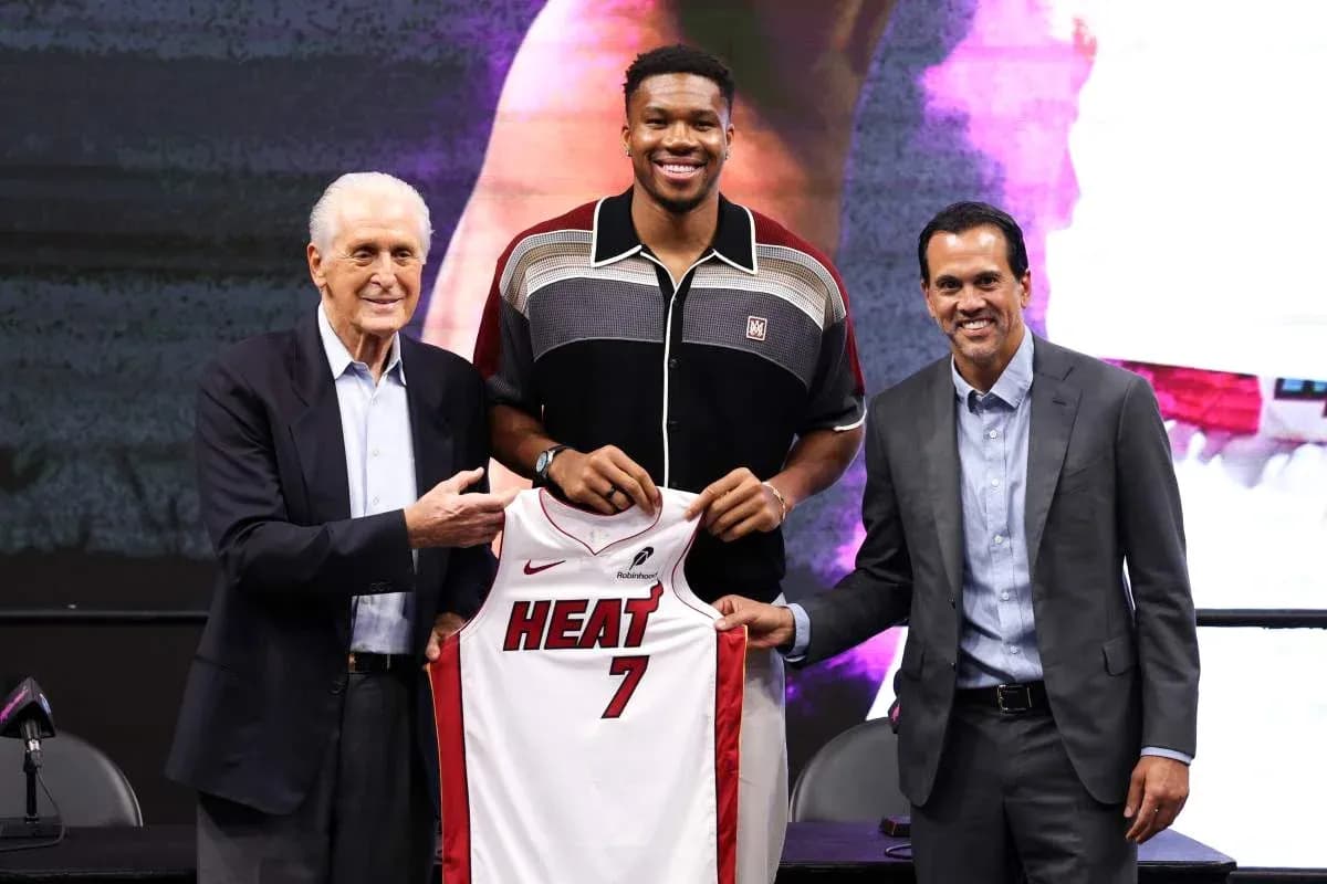 Player holding Miami Heat jersey at press conference Player holding Miami Heat jersey at press conference