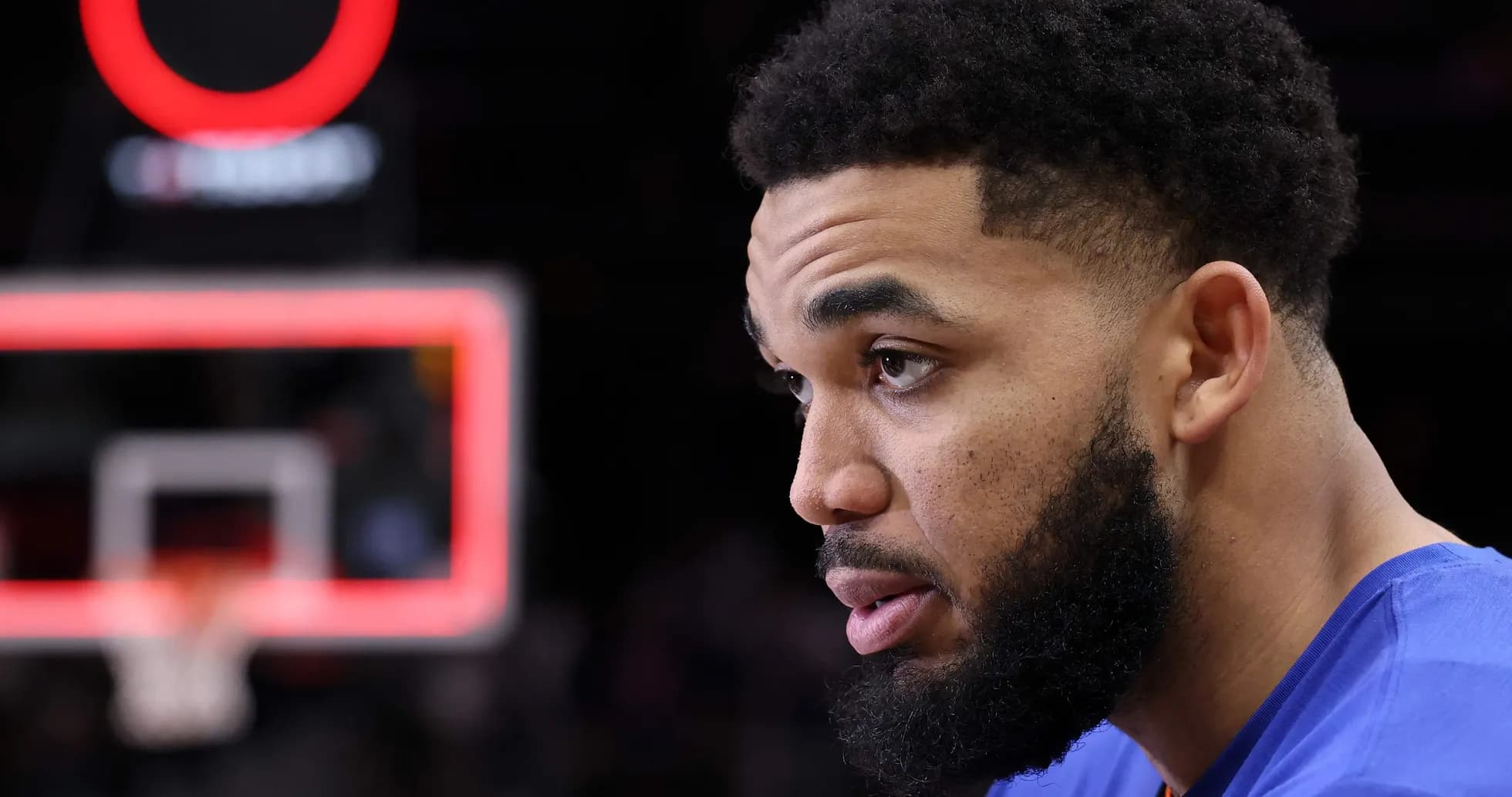 Player in blue jersey sitting near basketball hoop Player in blue jersey sitting near basketball hoop