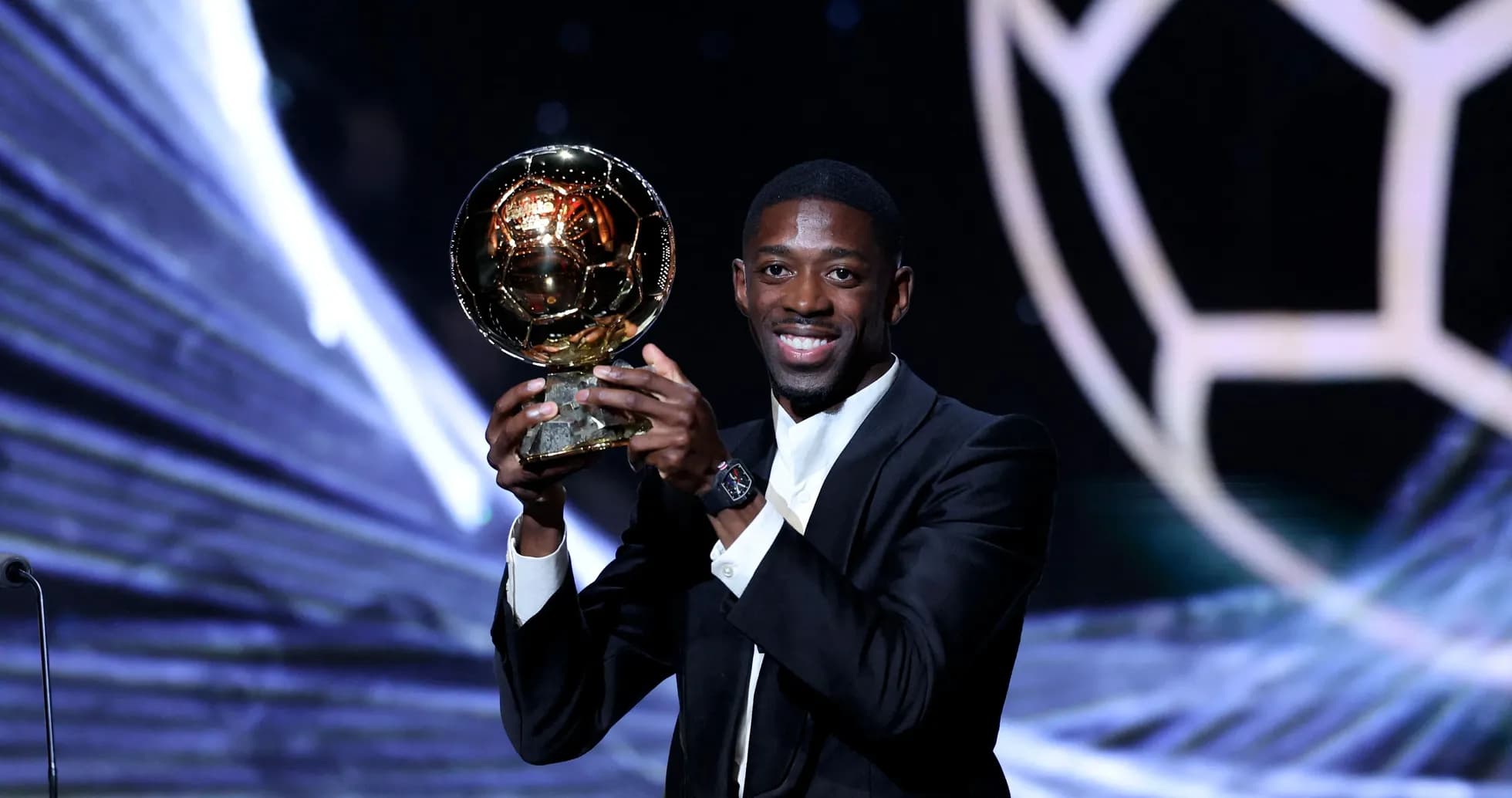 Player holding Ballon d'Or award on stage Player holding Ballon d'Or award on stage