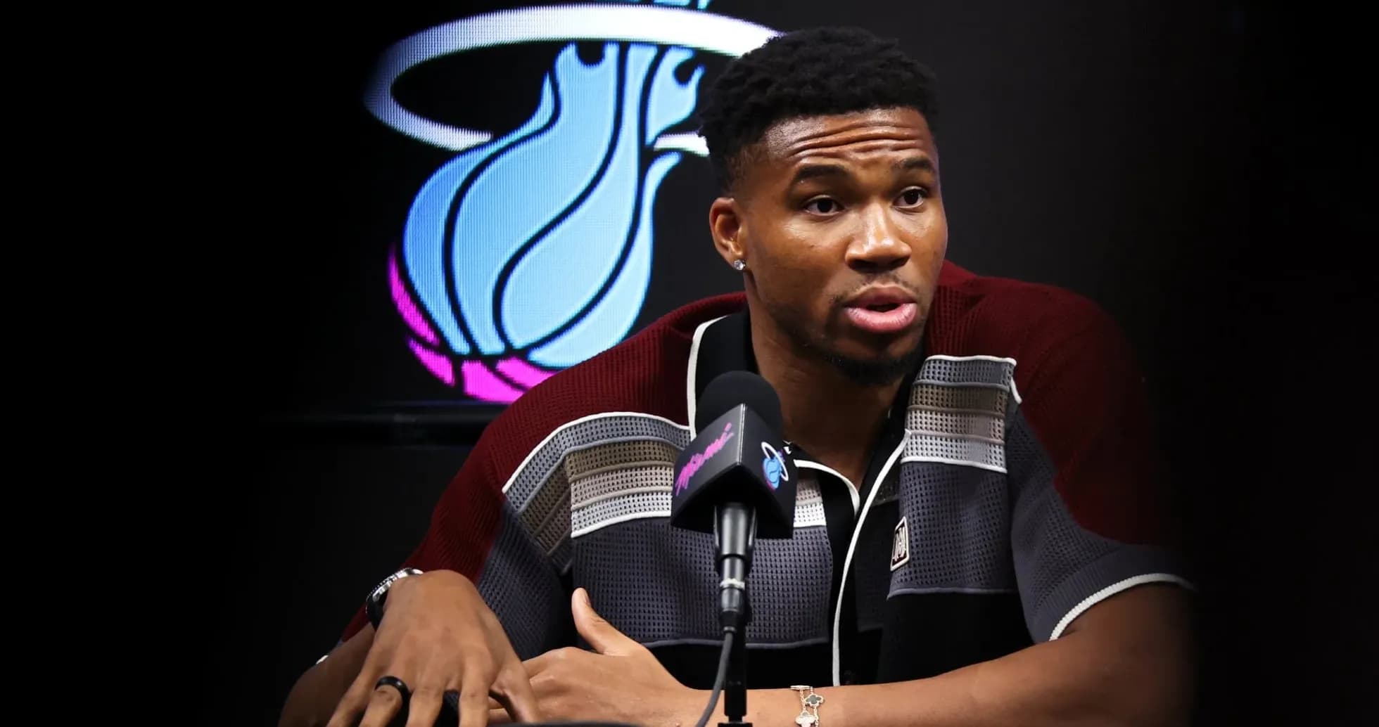 Player speaking at press conference with team logo Player speaking at press conference with team logo