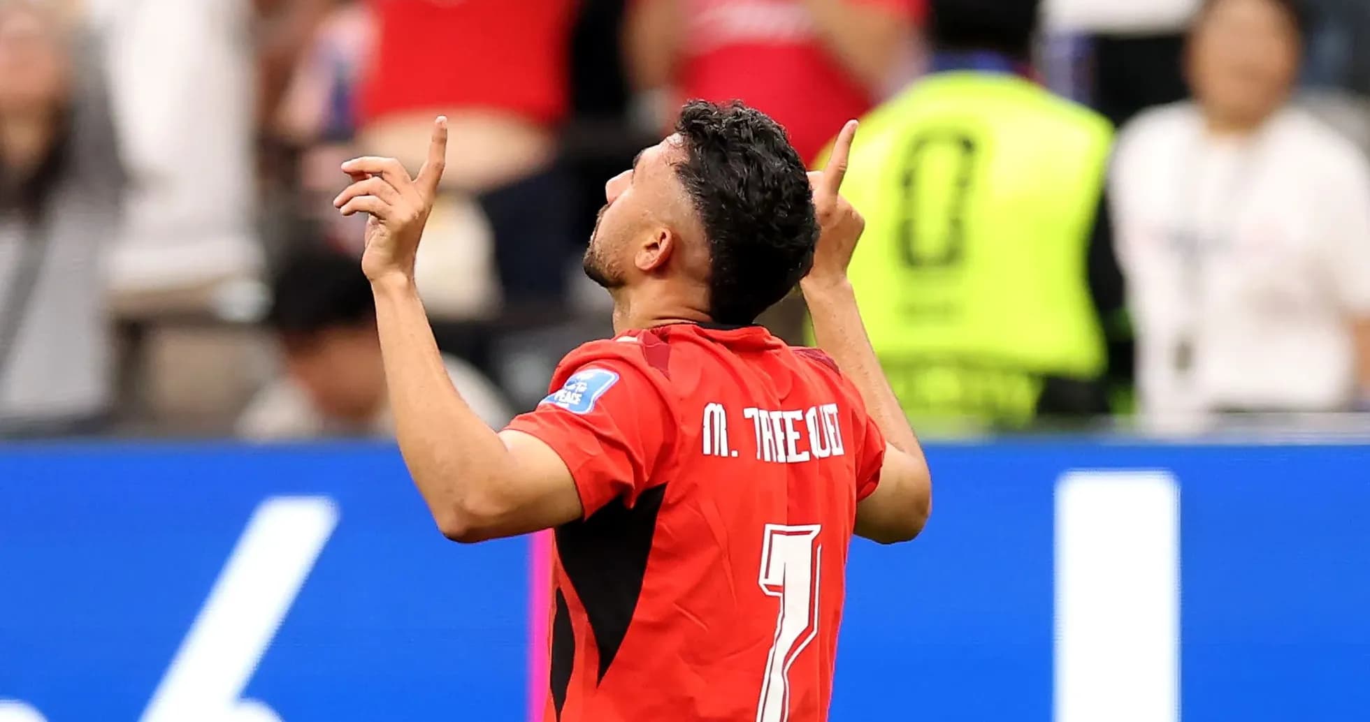 Player celebrating with arms raised during match Player celebrating with arms raised during match
