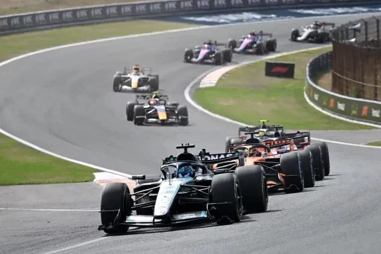 Several Formula 1 cars racing on a track Several Formula 1 cars racing on a track