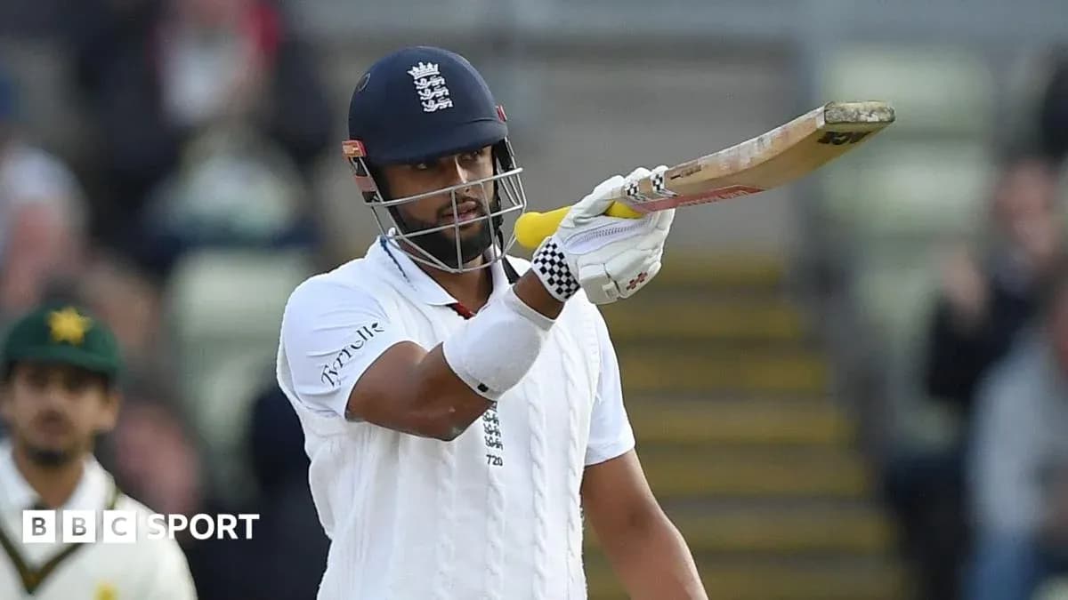 Cricketer signaling with bat during match Cricketer signaling with bat during match