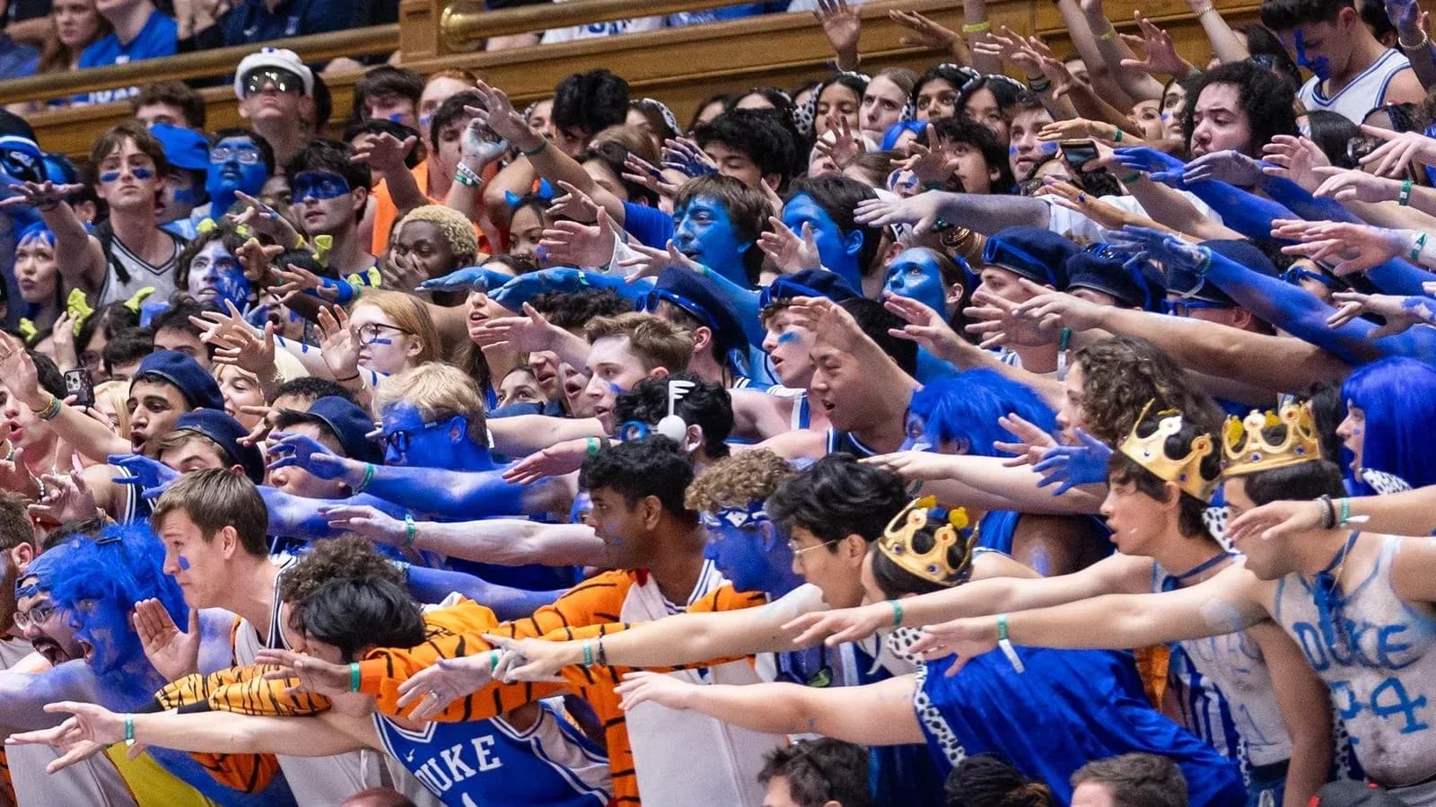 Duke University fans in blue cheering at a game Duke University fans in blue cheering at a game