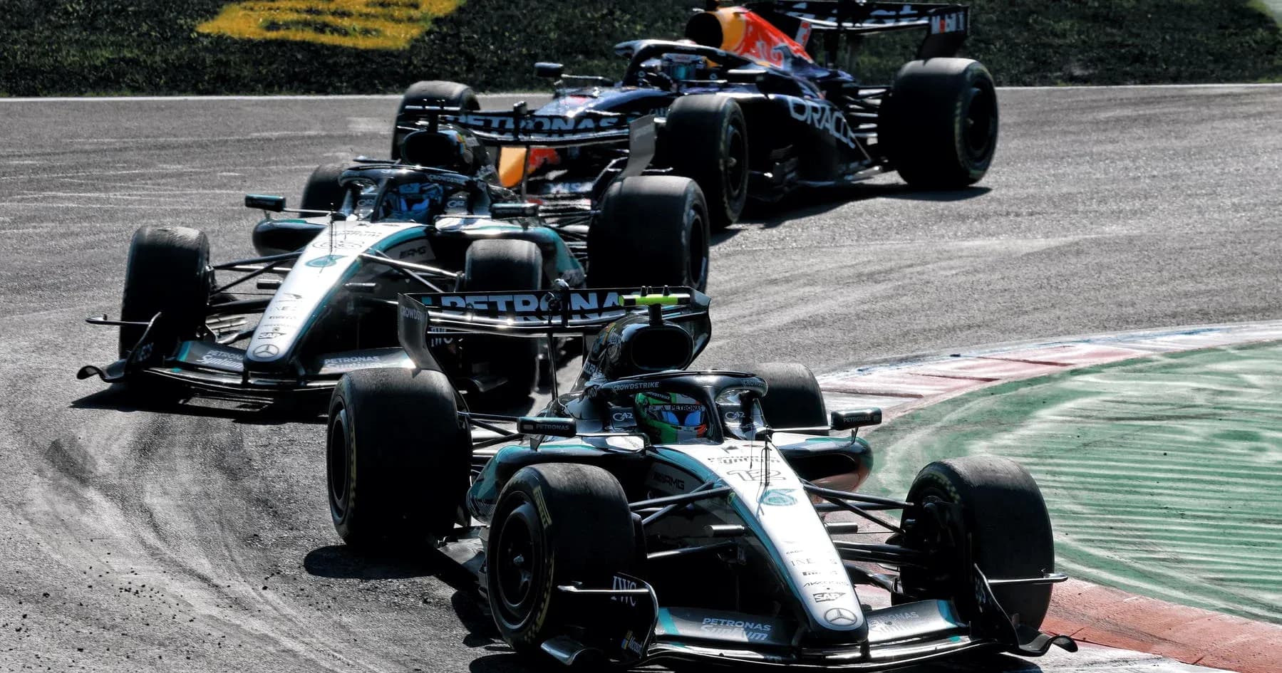 Three Formula 1 cars racing on track corner Three Formula 1 cars racing on track corner