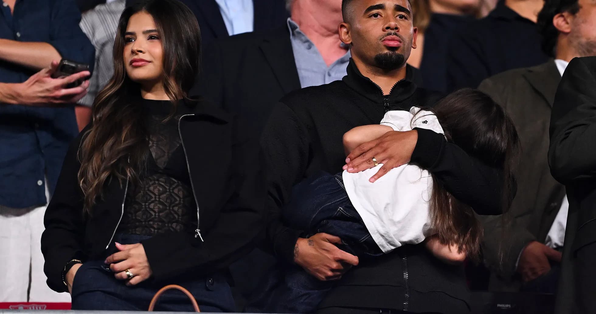 Family attending an event, holding a child Family attending an event, holding a child