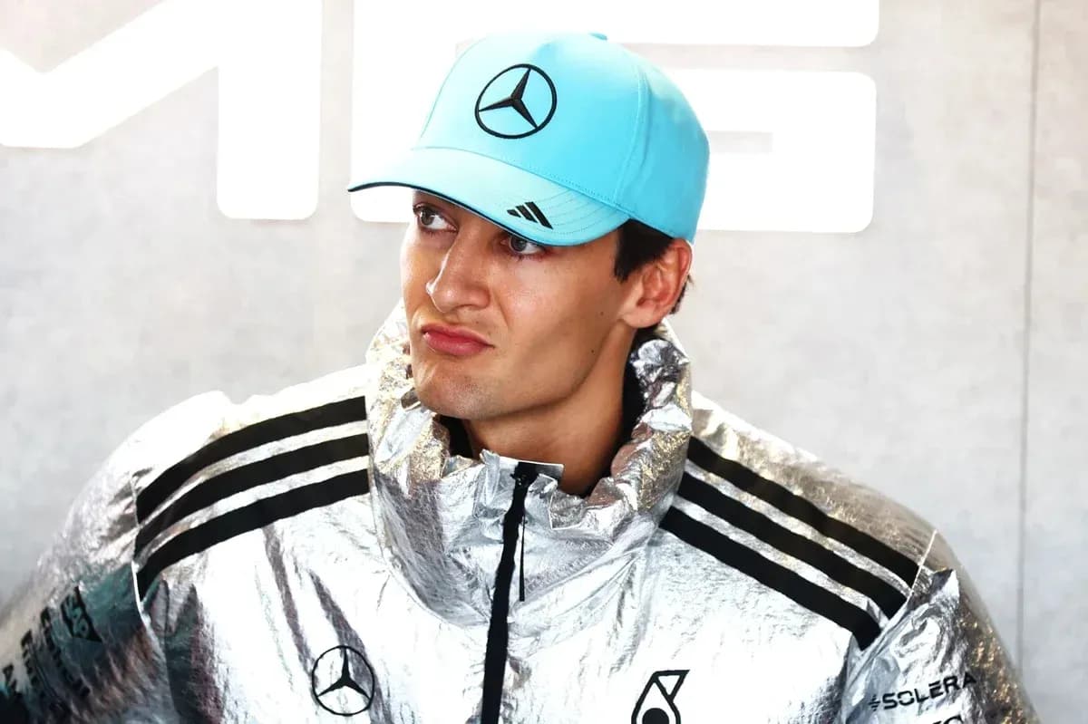 Driver wearing silver jacket and blue cap at event Driver wearing silver jacket and blue cap at event
