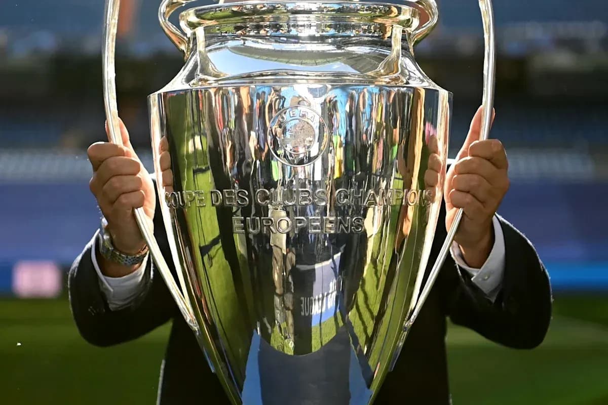 Person holding UEFA Champions League trophy outdoors Person holding UEFA Champions League trophy outdoors