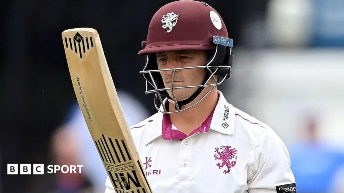 Cricketer from Somerset holding bat on field Cricketer from Somerset holding bat on field