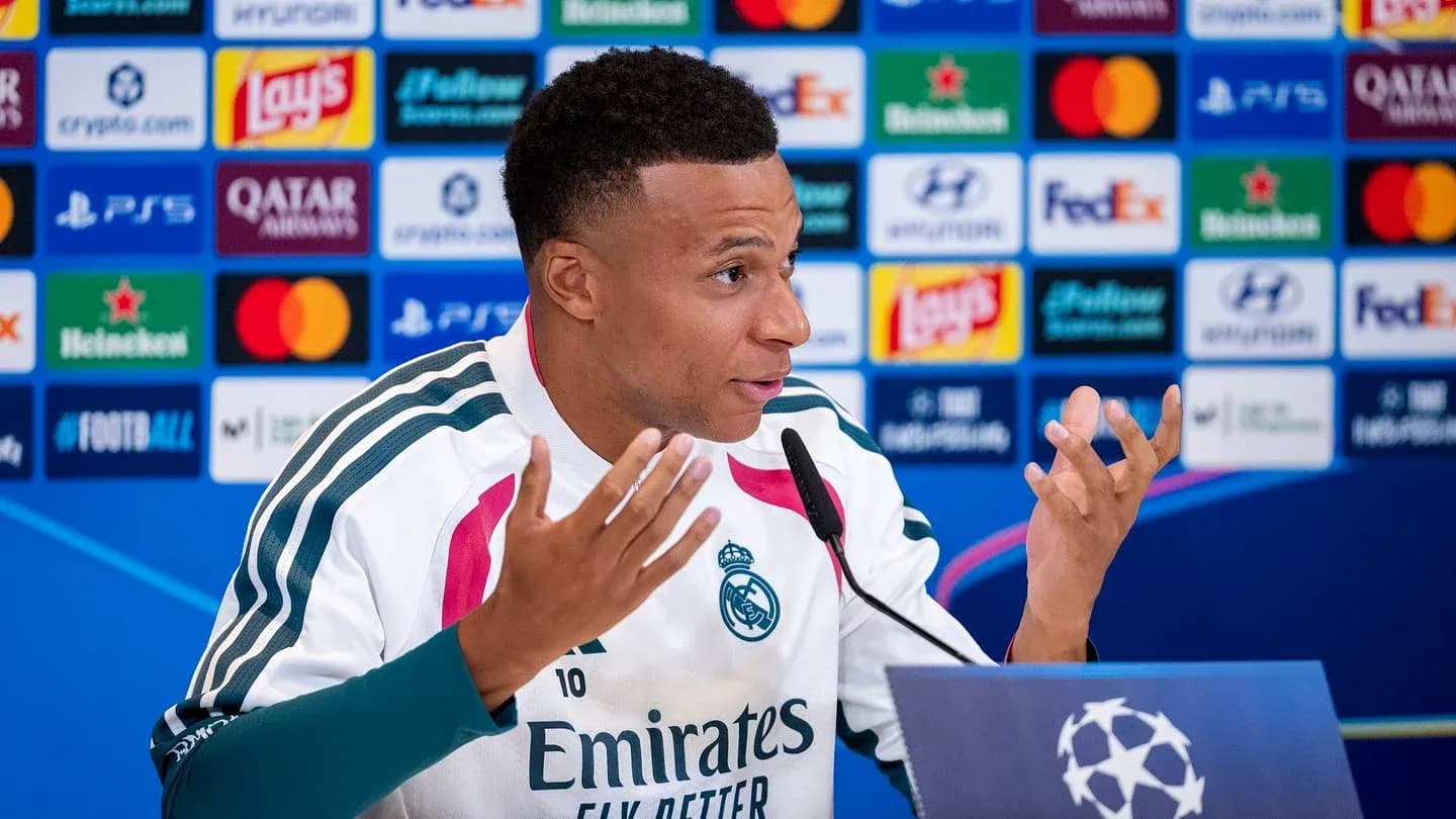 Player speaking at press conference with logos in background Player speaking at press conference with logos in background