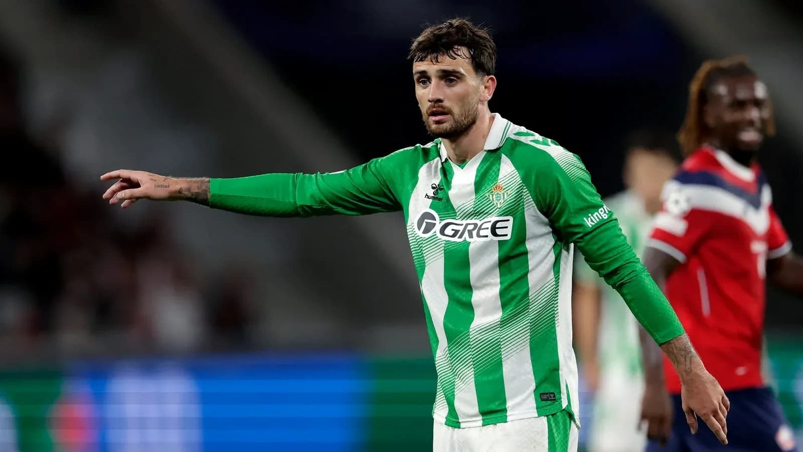 Player in green jersey directing teammates on field Player in green jersey directing teammates on field