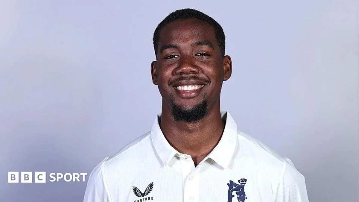Smiling cricketer wearing a white team shirt Smiling cricketer wearing a white team shirt