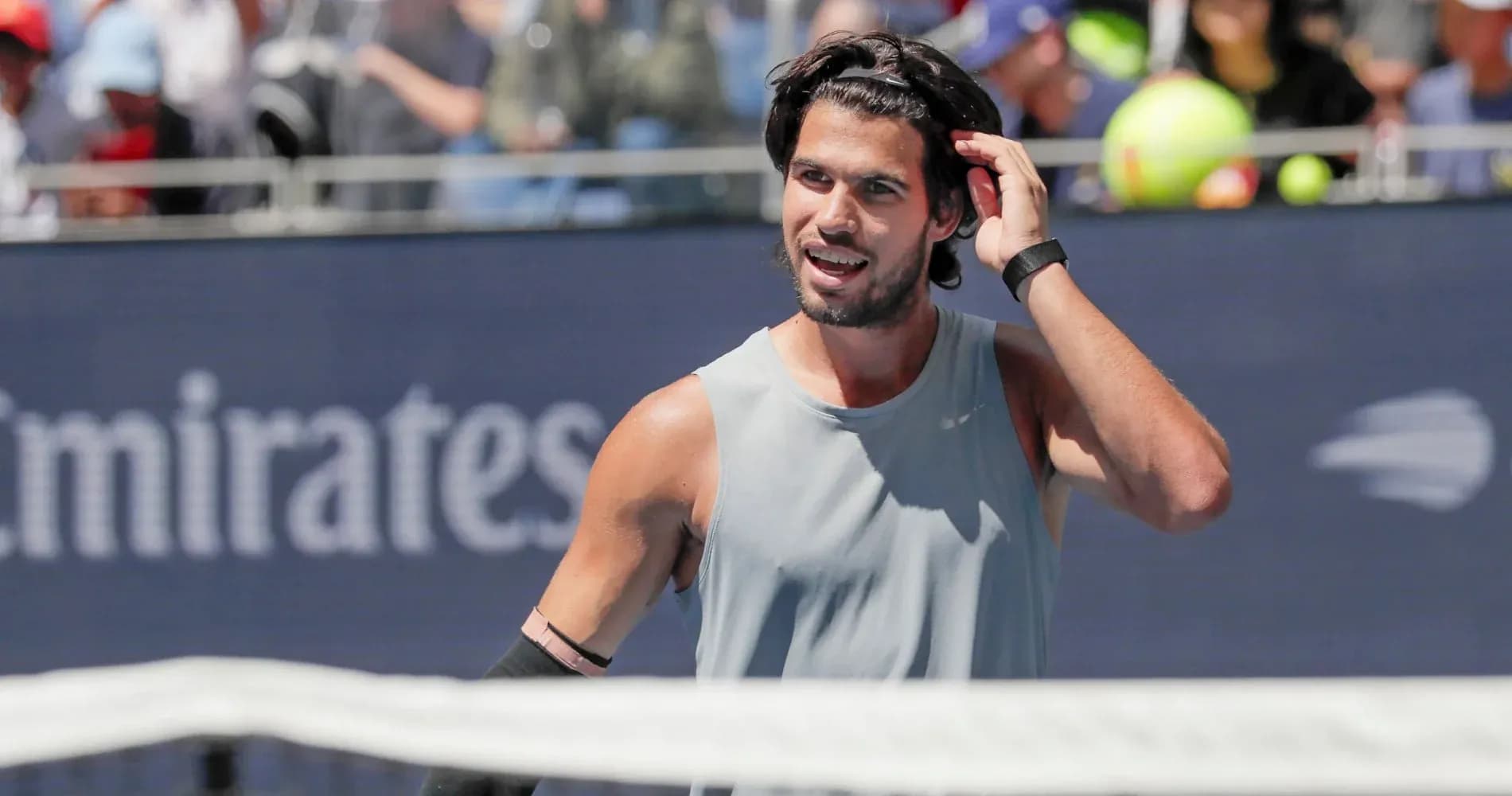 Tennis player adjusting his hair during match Tennis player adjusting his hair during match