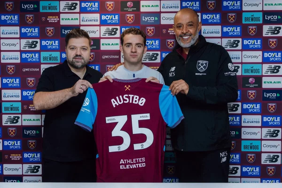 Player holding jersey with staff at signing event Player holding jersey with staff at signing event