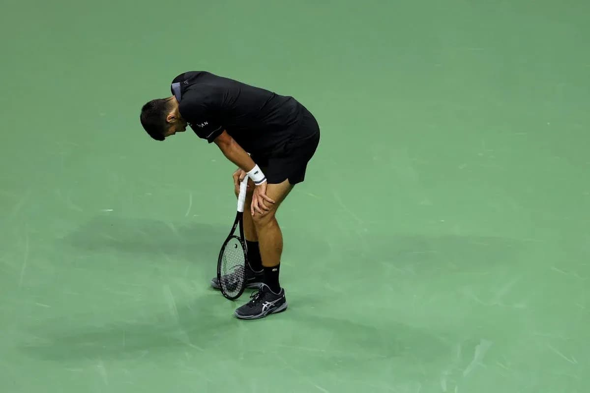Tennis player bent over holding racket on court Tennis player bent over holding racket on court