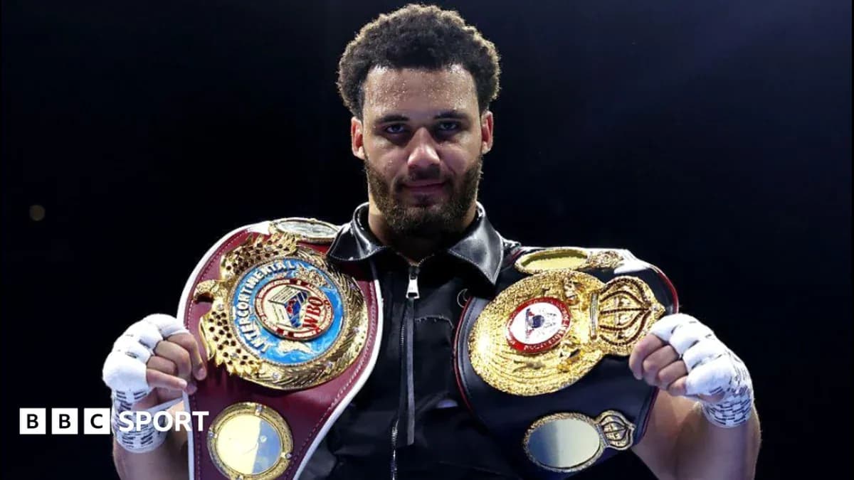 Boxer holding two championship belts in the ring Boxer holding two championship belts in the ring
