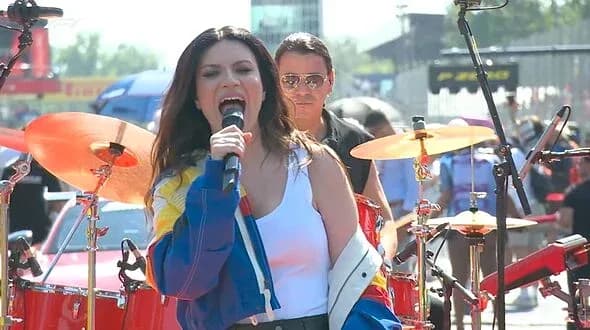 Singer performing on stage with band during event Singer performing on stage with band during event