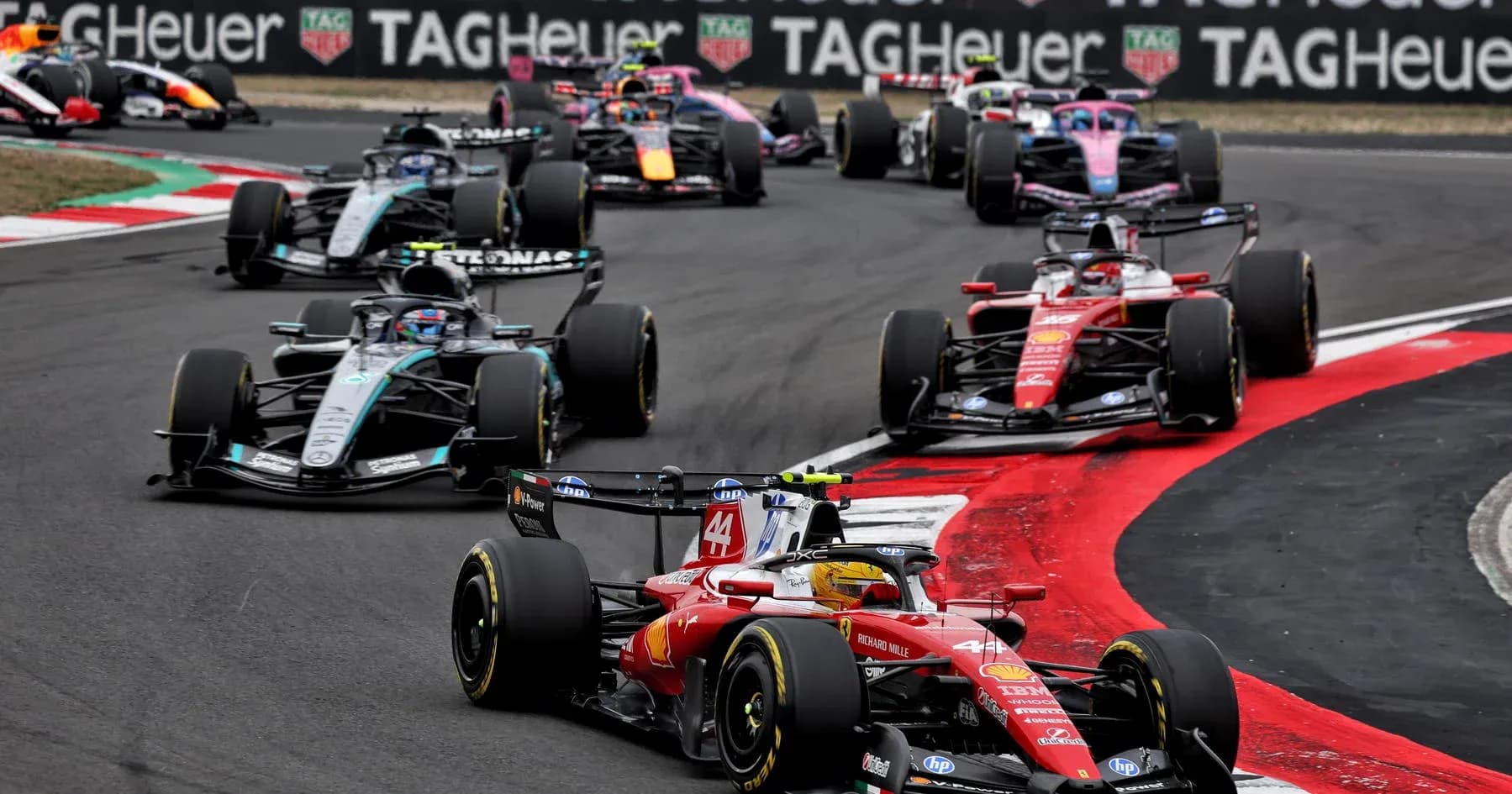Multiple Formula 1 cars racing on track corner Multiple Formula 1 cars racing on track corner