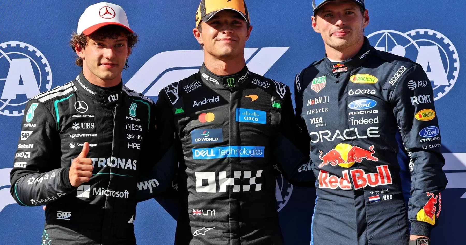 Three Formula 1 drivers posing on podium Three Formula 1 drivers posing on podium