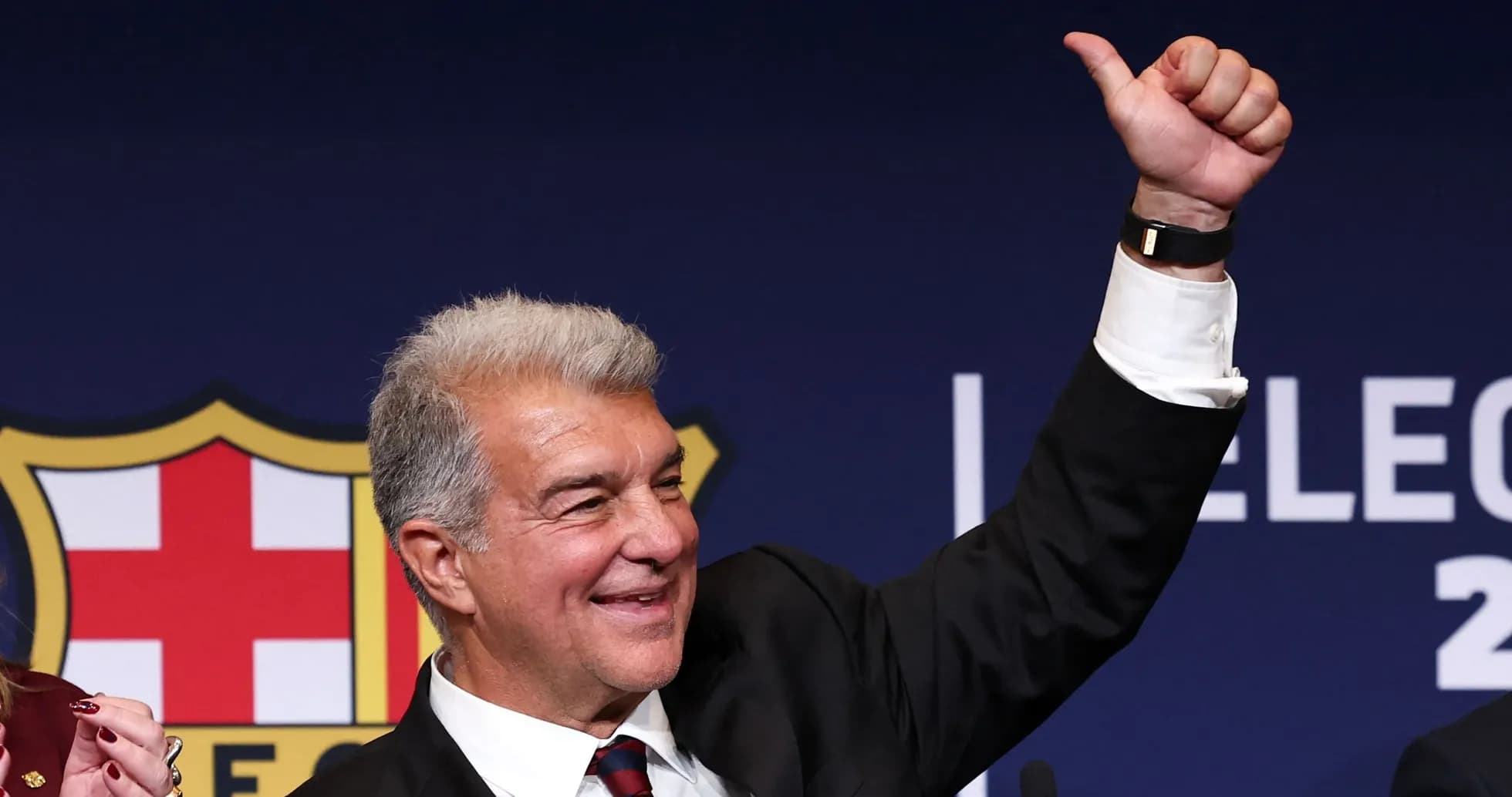 Man raising hand at election event with Barcelona logo Man raising hand at election event with Barcelona logo