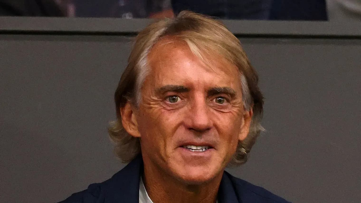 Man smiling in a sports venue setting Man smiling in a sports venue setting