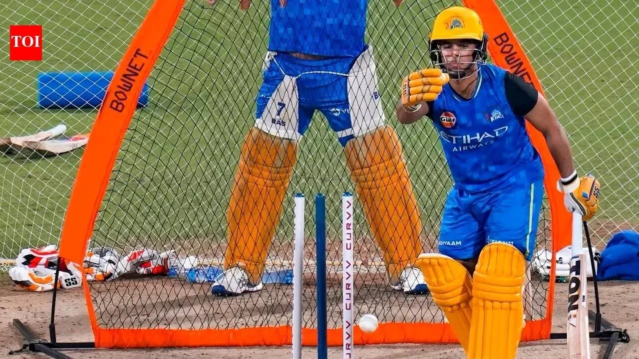 Batsman practicing in nets with bowler behind Batsman practicing in nets with bowler behind